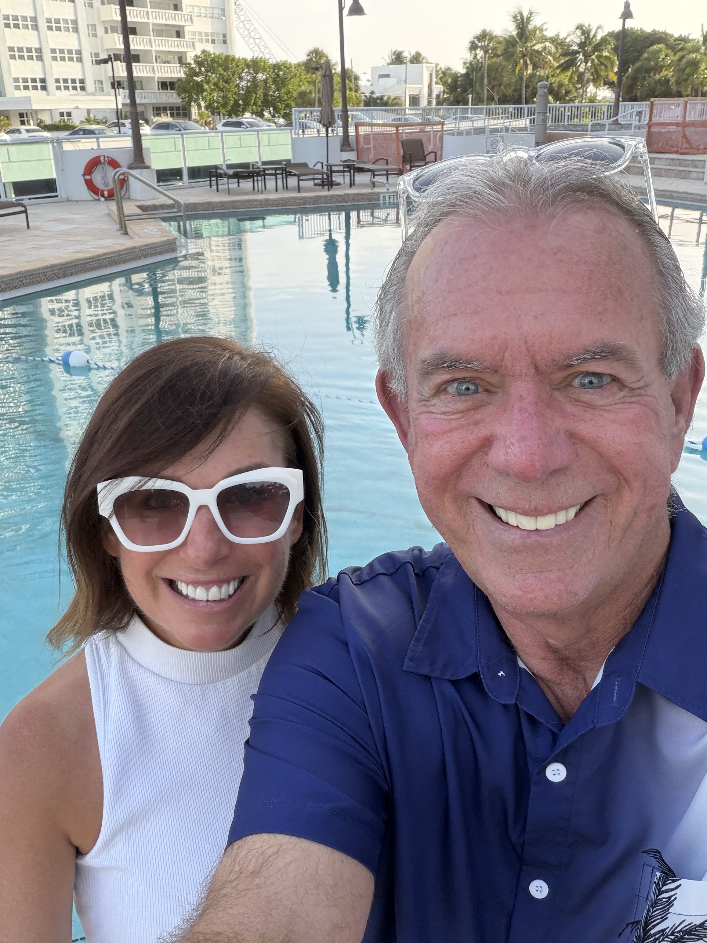 Mac and Laura smiling together by the pool